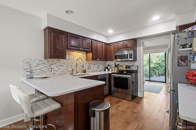 1125 Meadowglen Ct, Bloomfield Hills, MI 48304 - kitchen with stainless steel appliances, a peninsula, light wood-type flooring, and light countertops