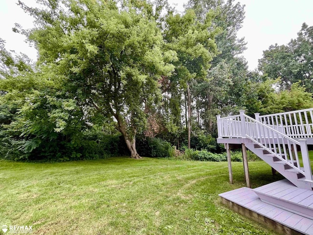 1421 Newcastle Dr, Davison, MI 48423 - view of grassy yard with a wooden deck, stairway, and view of wooded area
