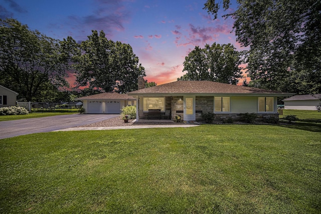 119 Burt Ave, Jackson, MI 49201 - ranch-style house featuring a chimney, stone siding, a lawn, and a detached garage