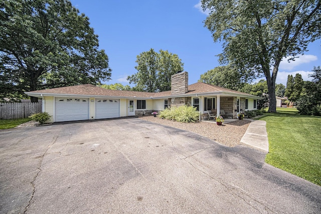 119 Burt Ave, Jackson, MI 49201 - ranch-style house featuring a garage, driveway, stone siding, and a chimney
