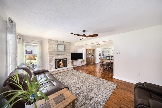 119 Burt Ave, Jackson, MI 49201 - living area with a ceiling fan, wood finished floors, a stone fireplace, and a textured ceiling