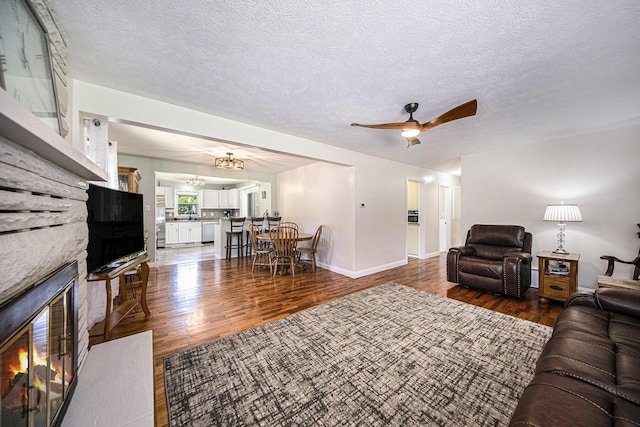 119 Burt Ave, Jackson, MI 49201 - living area with wood finished floors, ceiling fan, a fireplace, and a textured ceiling
