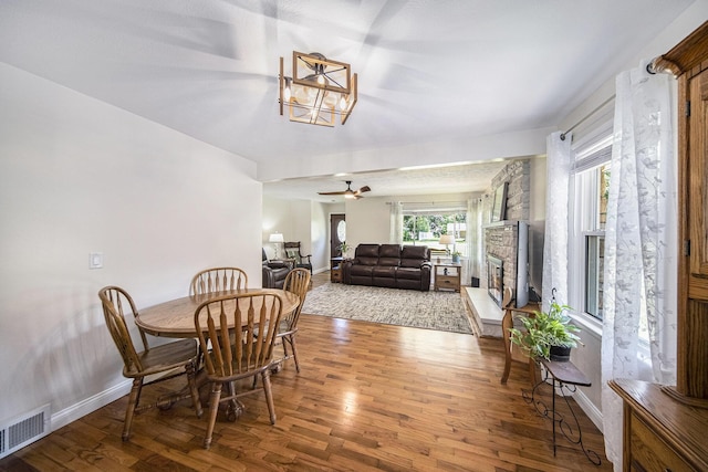 119 Burt Ave, Jackson, MI 49201 - dining area with wood finished floors, a stone fireplace, and a chandelier