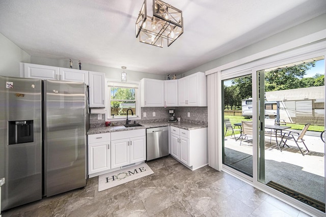 119 Burt Ave, Jackson, MI 49201 - kitchen featuring appliances with stainless steel finishes, tasteful backsplash, white cabinetry, and light stone countertops