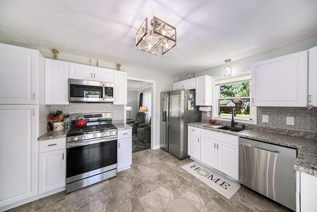 119 Burt Ave, Jackson, MI 49201 - kitchen with appliances with stainless steel finishes, tasteful backsplash, and white cabinetry