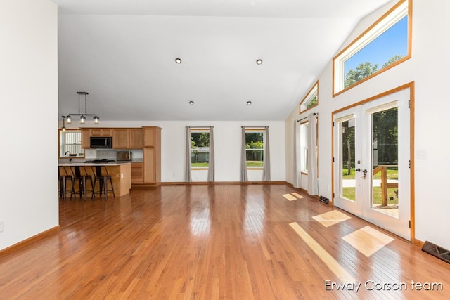 5599 Marsh Rd, Shelbyville, MI 49344 - unfurnished living room featuring french doors, light wood finished floors, and lofted ceiling
