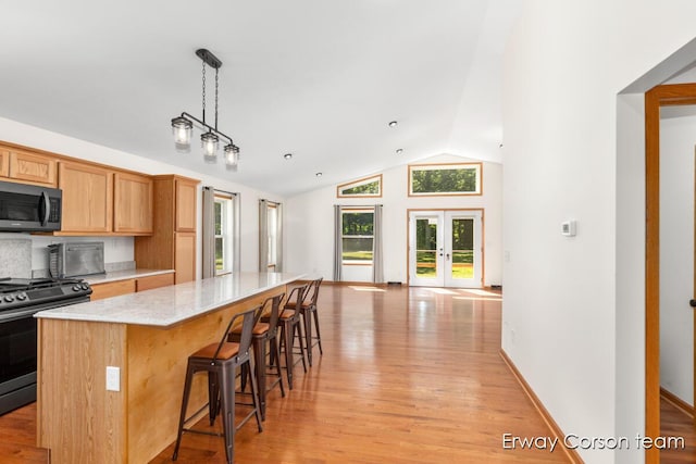 5599 Marsh Rd, Shelbyville, MI 49344 - kitchen with gas range, lofted ceiling, a kitchen island, light wood-type flooring, and light stone countertops