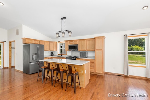 5599 Marsh Rd, Shelbyville, MI 49344 - kitchen with stainless steel fridge with ice dispenser, light countertops, vaulted ceiling, light wood-style flooring, and a kitchen island