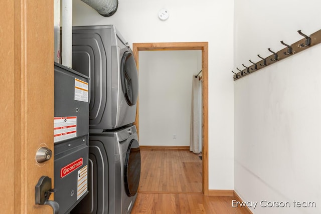 5599 Marsh Rd, Shelbyville, MI 49344 - washroom featuring estacked washer and dryer and wood finished floors