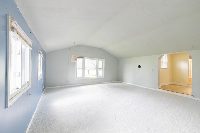 8876 Sheldon Rd, Plymouth, MI 48170 - additional living space featuring light colored carpet, vaulted ceiling, and arched walkways