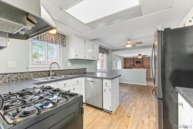 12360 Moers Dr, Sterling Heights, MI 48313 - kitchen with appliances with stainless steel finishes, light wood finished floors, dark countertops, and a peninsula