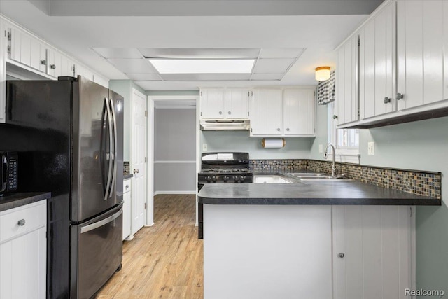 12360 Moers Dr, Sterling Heights, MI 48313 - kitchen with under cabinet range hood, dark countertops, black appliances, a peninsula, and light wood-style flooring