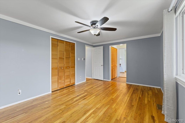 12360 Moers Dr, Sterling Heights, MI 48313 - unfurnished bedroom featuring ornamental molding, light wood-style flooring, two closets, and ceiling fan