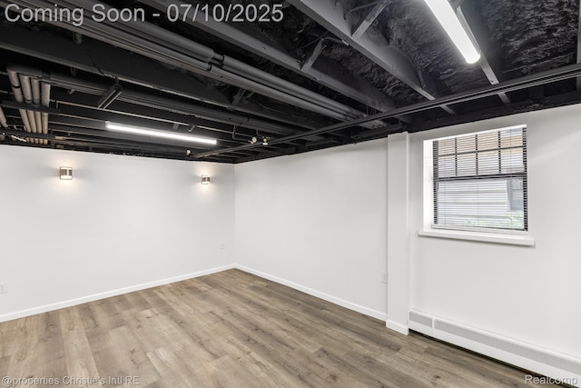 120 Seward St Unit U2, Detroit, MI 48202 - below grade area featuring a baseboard radiator and wood finished floors