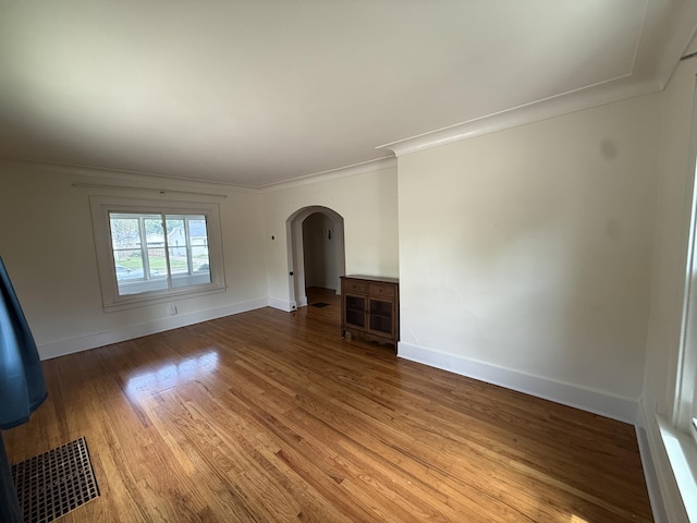 1316 Vassar Dr, Kalamazoo, MI 49001 - unfurnished living room with arched walkways, wood finished floors, and ornamental molding
