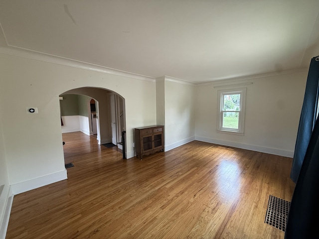 1316 Vassar Dr, Kalamazoo, MI 49001 - unfurnished living room with arched walkways, wood finished floors, and ornamental molding