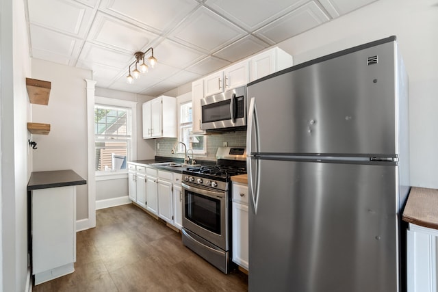 716 17th St, Jackson, MI 49203 - kitchen with appliances with stainless steel finishes, white cabinetry, dark countertops, and an ornate ceiling
