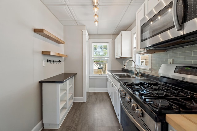 716 17th St, Jackson, MI 49203 - kitchen featuring appliances with stainless steel finishes, open shelves, white cabinets, dark countertops, and decorative backsplash