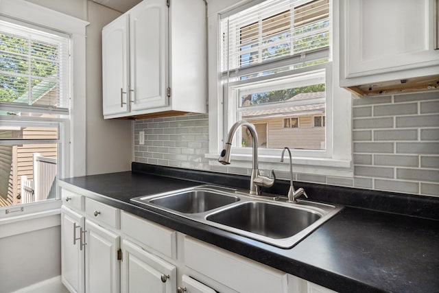 716 17th St, Jackson, MI 49203 - kitchen featuring dark countertops, white cabinetry, and backsplash