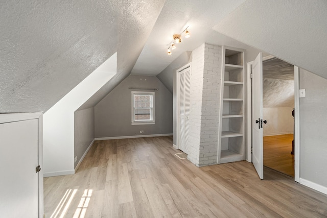 716 17th St, Jackson, MI 49203 - additional living space featuring a textured ceiling, wood finished floors, and vaulted ceiling