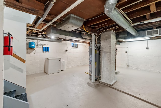 716 17th St, Jackson, MI 49203 - below grade area featuring water heater and white refrigerator