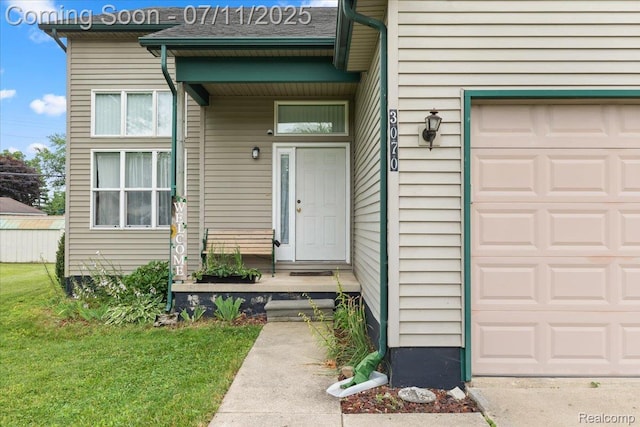3070 10th St, Monroe, MI 48162 - view of exterior entry with a garage and a lawn