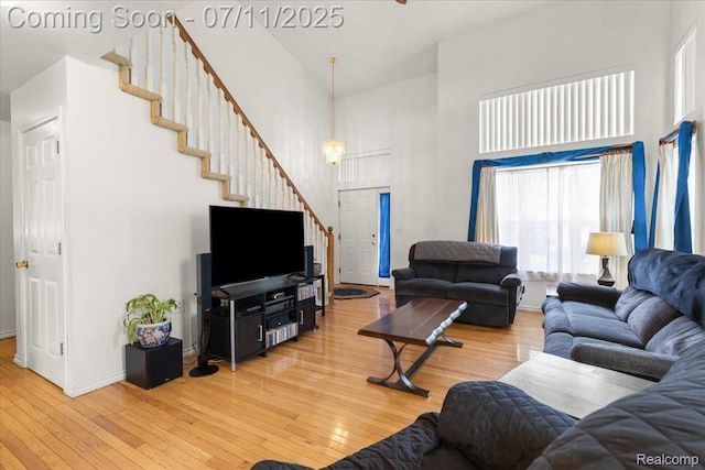 3070 10th St, Monroe, MI 48162 - living room with a towering ceiling, stairs, light wood-type flooring, and a chandelier