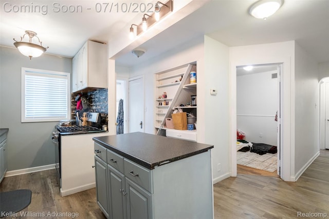 15326 Brookfield St, Livonia, MI 48154 - kitchen featuring stainless steel gas range, light wood-style floors, dark countertops, gray cabinets, and white cabinets