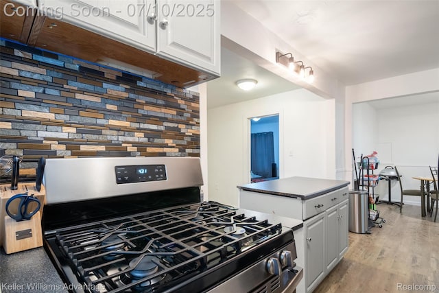 15326 Brookfield St, Livonia, MI 48154 - kitchen with stainless steel gas range, white cabinets, dark countertops, and light wood-style floors