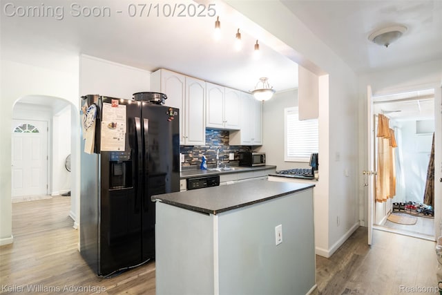 15326 Brookfield St, Livonia, MI 48154 - kitchen featuring refrigerator with ice dispenser, arched walkways, dark countertops, white cabinets, and backsplash