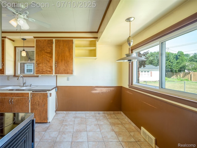 35622 Minton St, Livonia, MI 48150 - kitchen featuring brown cabinets, wainscoting, decorative light fixtures, ceiling fan, and cooktop
