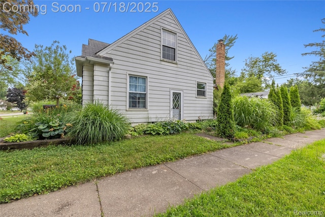 28589 Everett St, Southfield, MI 48076 - view of side of home with a lawn, roof with shingles, and a chimney
