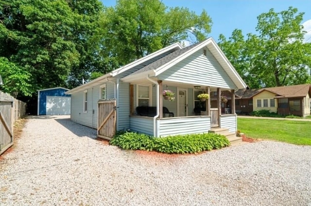 10637 Portage Rd, Portage, MI 49002 - view of front facade featuring driveway, covered porch, an outdoor structure, a detached garage, and a front lawn