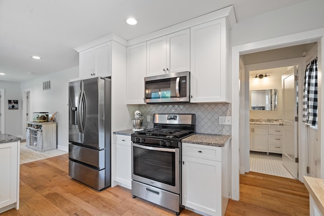 10637 Portage Rd, Portage, MI 49002 - kitchen featuring appliances with stainless steel finishes, light wood-style floors, white cabinets, and recessed lighting