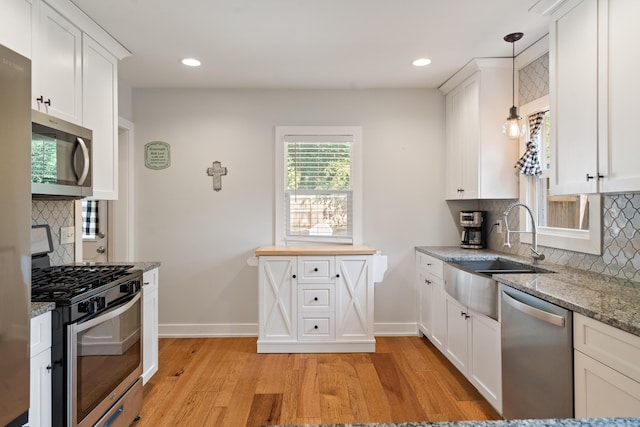 10637 Portage Rd, Portage, MI 49002 - kitchen featuring stainless steel appliances, backsplash, light wood finished floors, white cabinetry, and recessed lighting