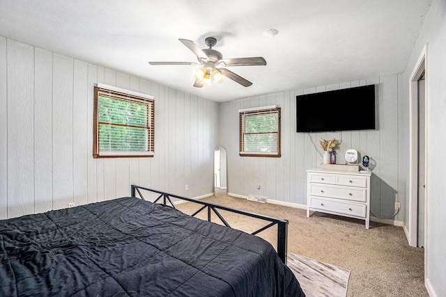 15645 Rich Ln, Hickory Corners, MI 49060 - bedroom featuring multiple windows, carpet flooring, ceiling fan, and wooden walls