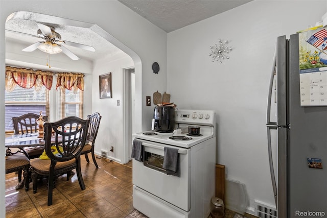 19359 Montrose St, Detroit, MI 48235 - kitchen with freestanding refrigerator, electric stove, a ceiling fan, arched walkways, and a textured ceiling