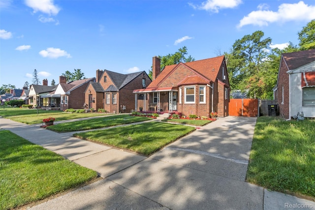 19359 Montrose St, Detroit, MI 48235 - tudor house with brick siding, concrete driveway, a residential view, and a chimney
