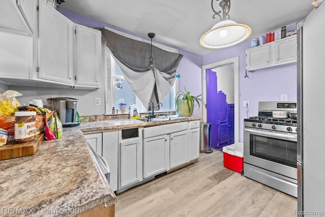 22 W Henry St, River Rouge, MI 48218 - kitchen with appliances with stainless steel finishes, white cabinetry, light countertops, and light wood-style flooring