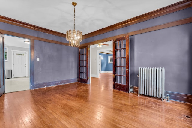 1227 Longfellow St, Detroit, MI 48202 - spare room featuring radiator heating unit, a chandelier, wood-type flooring, and crown molding