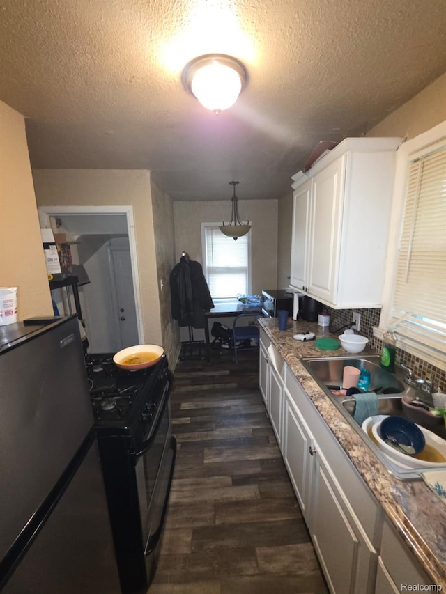 20460 Appoline St, Detroit, MI 48235 - kitchen featuring dark wood-type flooring, white cabinetry, stainless steel gas stove, a textured ceiling, and refrigerator