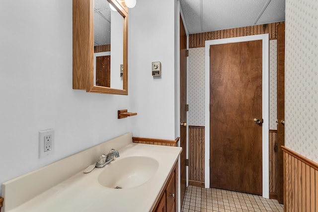 263 Westshore Dr, Jerome, MI 49249 - bathroom featuring wainscoting, wallpapered walls, vanity, wood walls, and tile patterned flooring