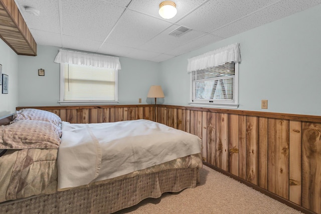 263 Westshore Dr, Jerome, MI 49249 - carpeted bedroom with a paneled ceiling, wainscoting, multiple windows, and wood walls