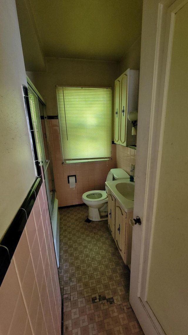 1109 Meadowbrooke St, Inkster, MI 48141 - bathroom featuring tile walls, vanity, tile patterned floors, and shower / bath combination with glass door