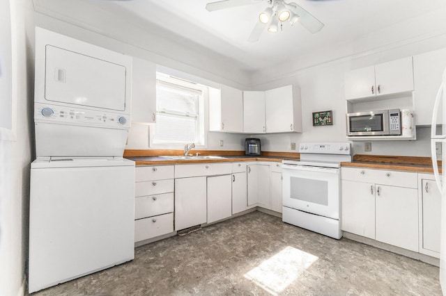 617 E Thorn St, Hastings, MI 49058 - kitchen with white electric stove, stacked washer / drying machine, stainless steel microwave, white cabinets, and ceiling fan
