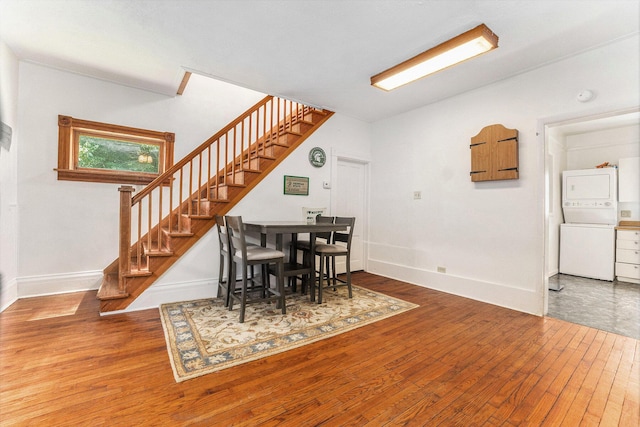 617 E Thorn St, Hastings, MI 49058 - dining room featuring stacked washer / dryer, stairway, and hardwood / wood-style flooring