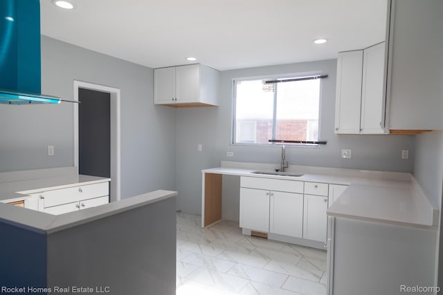 3926 Three Mile Dr, Detroit, MI 48224 - kitchen with white cabinets, recessed lighting, light marble finish floors, ventilation hood, and light countertops