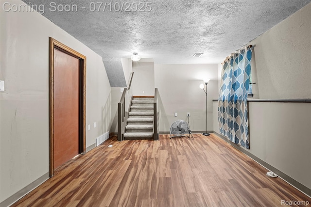 1560 Mercedes St, West Bloomfield, MI 48324 - finished basement with wood finished floors, a textured ceiling, and stairs