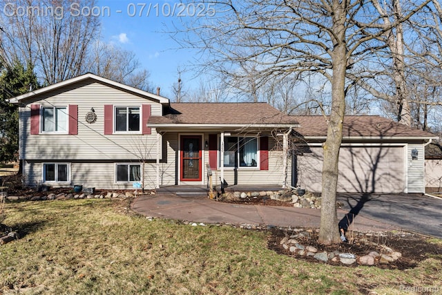 1560 Mercedes St, West Bloomfield, MI 48324 - tri-level home with asphalt driveway, a front lawn, a garage, covered porch, and roof with shingles