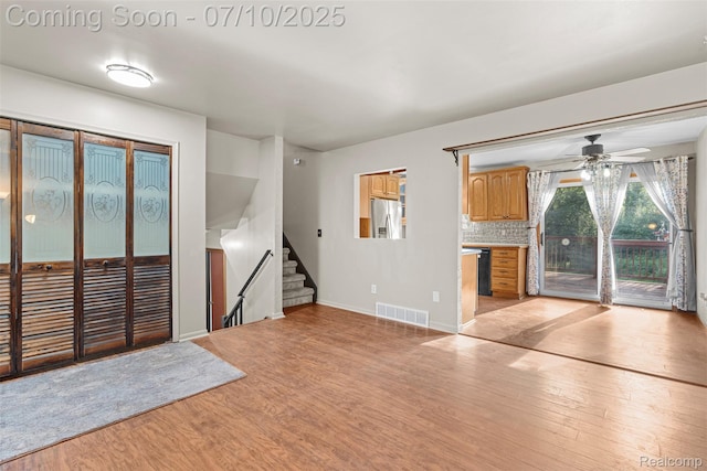 1560 Mercedes St, West Bloomfield, MI 48324 - unfurnished living room featuring light wood-style flooring, stairs, and ceiling fan